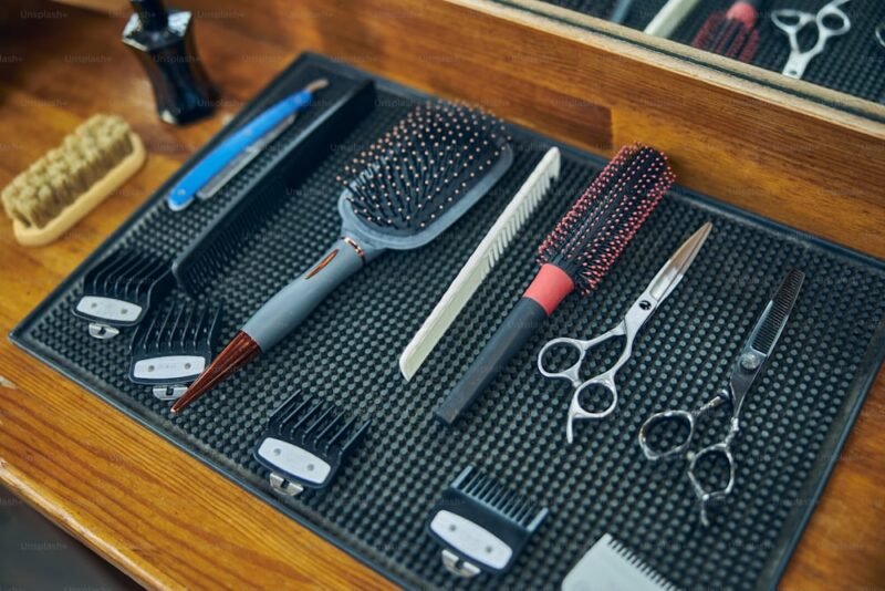 Flat lay of men’s grooming tools including trimmer, razor, beard brush, and moisturizer