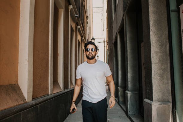 Man walking confidently in old town street in casual wear with groomed appearance