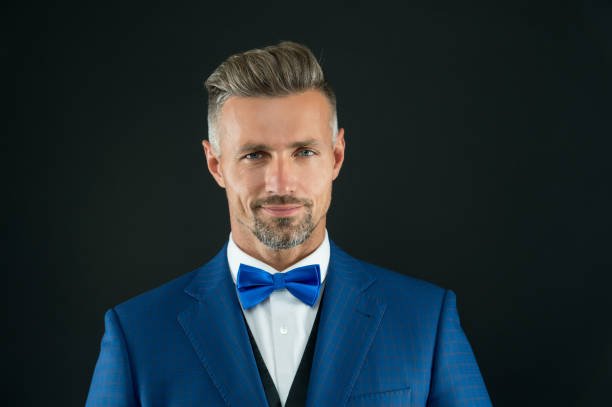 A well groomed handsome bearded gentleman in macho wear, blue wedding tuxedo